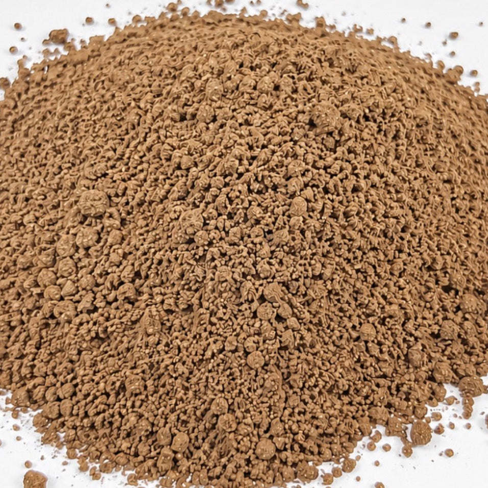 A mound of fine medium roast coffee grounds, shown in a close-up shot against a white background.